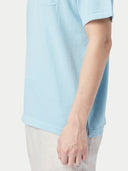 Man wearing a light blue polo shirt and white pants against a plain background #color_forget-blue