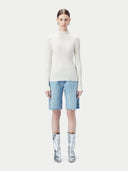 White ribbed knit cashmere sweater on a light beige background #color_pure-white