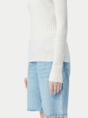White ribbed knit cashmere sweater on a light beige background #color_pure-white