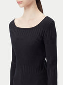A woman wearing a ribbed cotton silk cashmere blend sweater in black color with a V-neckline and long sleeves, paired with a pair of light blue denim shorts. 
#color_graphite-black