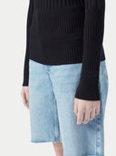 A woman wearing a ribbed cotton silk cashmere blend sweater in black color with a V-neckline and long sleeves, paired with a pair of light blue denim shorts. 
#color_graphite-black