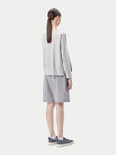 A light gray long-sleeve crewneck sweater displayed flat against a light gray background. #color_warm-light