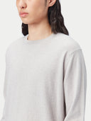 Person wearing a light gray long-sleeve shirt and light-colored pants on a white background #color_warm-light
