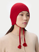 Ultimate Warmth Knit Tie Hat Chili Pepper worn by model, side view on white background #color_warm-red