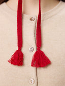 Ultimate Warmth Knit Tie Hat Chili Pepper worn by model, side view on white background #color_warm-red