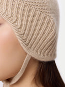 Close-up of a beige knitted bonnet worn by a person