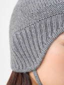 Ultimate Warmth Knit Tie Hat Dim Gray  worn by model, detail view on white background
