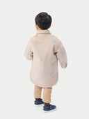 A child wearing a beige cashmere sewn jacket with snap-button design.  #color_beige