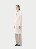 Women's Notch Lapel Midi-Length Cashmere Coat White worn by model side view on white background