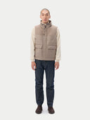 A sleeveless beige cashmere vest with a high collar, front zipper, and two large front flap pockets, shown flat against a light gray background. #color_taupe