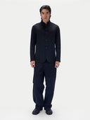Full-length view of a man wearing the black cashmere stand-collar jacket with dark trousers, against a light gray studio background.