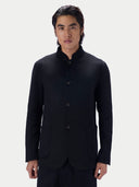 A man wearing the black cashmere stand-collar jacket buttoned, shown from the waist up against a light gray background.