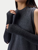 A close-up of a model wearing a dark gray ribbed knit sweater vest with matching ribbed knit arm warmers, shown against a plain light background.