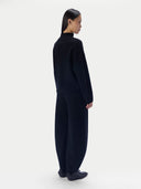 Black sleeveless top with a draped design worn by a model on a white background.