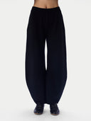 Black wide-leg harem pants worn by a model, shown from the waist down against a plain white studio background.