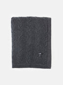 Dark gray knitted blanket with a brand logo on a white background.