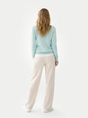 Women's  Blue Glass Cashmere V-Neck Sweater worn by model, back view on white background  
