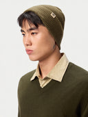 Model wearing the Seamless Cashmere Rib Knit Beanie in Muted Green, close front view