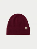 The Seamless Cashmere Rib Knit Beanie in Wine Red, flat lay front view