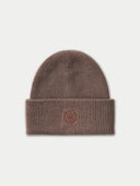 A ribbed knit beanie in a muted taupe-brown color, featuring a small embroidered monogram logo on the front of the folded cuff, set against a light off-white background.