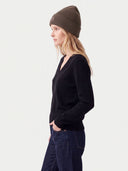 Model wearing the Women's Seamless Cashmere Ribbed Beanie in Cocoa, three-quarter side view