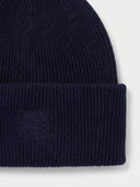 Close-up of the Women's Seamless Cashmere Ribbed Beanie in Navy, showing the turn-up cuff with the tonal embroidered monogram and the rib knit