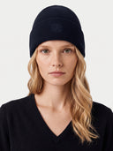 Model wearing the Women's Seamless Cashmere Ribbed Beanie in Navy, close front view