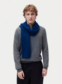 Model wearing the Fisherman Knit Scarf in Deep Blue, worn around the neck