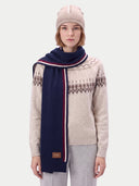 The navy intarsia-stripe scarf wrapped once around the neck, one long end with the GOBI leather patch hanging down the front.