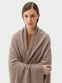 Model wrapped in the Natural Color Cashmere Knit Blanket in Taupe, close front view