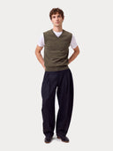Full-length front view of a man wearing the olive green Timeless V-Neck Cashmere Vest with black trousers
