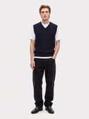 Model wearing the Cashmere Cable-Knit V-Neck Vest in Navy over a white T-shirt, full-length front view