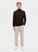 Model wearing the Seamless Cashmere Turtleneck Sweater in Olive Brown, full-length front view