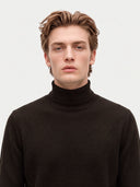 Model wearing the Seamless Cashmere Turtleneck Sweater in Olive Brown, close front view