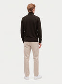 Model wearing the Seamless Cashmere Turtleneck Sweater in Olive Brown, back view