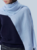 Close-up of the Muted Blue woven scarf draped over the shoulder, showing sheer texture and fringe