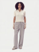 Model wearing the Pure White cashmere silk rib-knit polo sweater with wide grey jeans, full-length front view