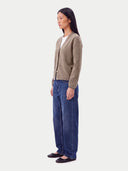 Model wearing the Cashmere V-Neck Cardigan in Taupe, three-quarter side view