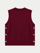 A sleeveless crewneck sweater vest in deep burgundy, featuring decorative silver buttons along the side seams, shown flat against a light gray background.
