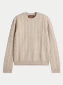 A beige cable-knit crewneck sweater with a brown brand label at the collar, displayed flat against a light gray background.