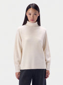 Model wearing the Cashmere Links-Knit Turtleneck Sweater in White, front view
