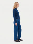 Model wearing the Seamless Cashmere Mock Neck Sweater in Deep Blue, three-quarter side view