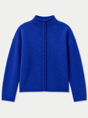 A royal blue knit sweater with a mock neck and a central braided cable detail running down the front, displayed on a light gray background.