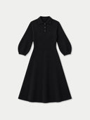 A black long-sleeve polo dress with a flared skirt, displayed on a clean light gray background.