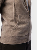 Close-up of the curved smiley pocket and zip on the taupe cashmere hoodie