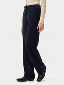 Model wearing the Cashmere Drawstring Straight-Leg Knit Pants in Navy, three-quarter side view