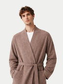 Man wearing a brown robe against a white background