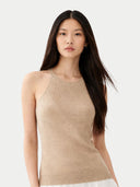 Woman wearing a beige sleeveless cashmere top against a white background. #color_warm-grey