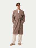 Man wearing a brown robe over a white shirt on a white background