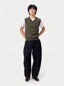 Full-length front view of a man wearing the olive green Timeless V-Neck Cashmere Vest with black trousers